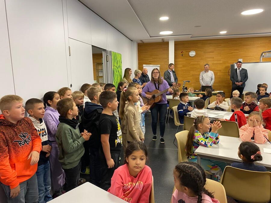 Schulkinder singen im Klassenzimmer ein Begrüßungslied für den Landrat