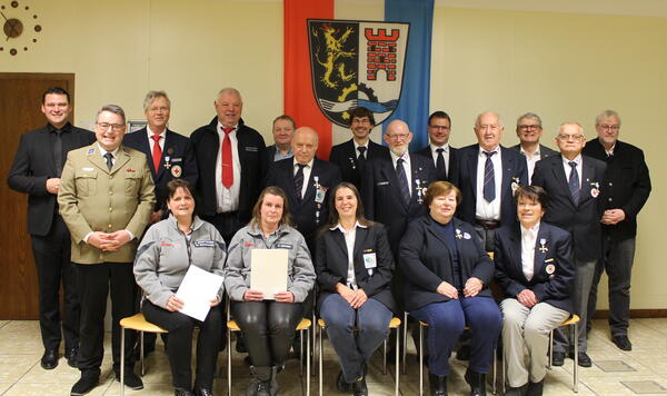 Geehrte von BRK und JUH gemeinsam mit Landrat Ebeling, MdL Martin Scharf und Funktionären vor der Fahne des Landkreises Schwandorf
