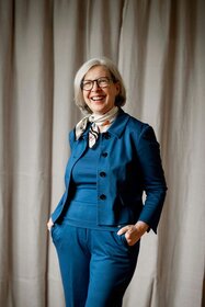 Freundlich lachende Frau in blauer Kleidung 