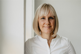 Frau mit blondem Haar blickt freundlich in die Kamera